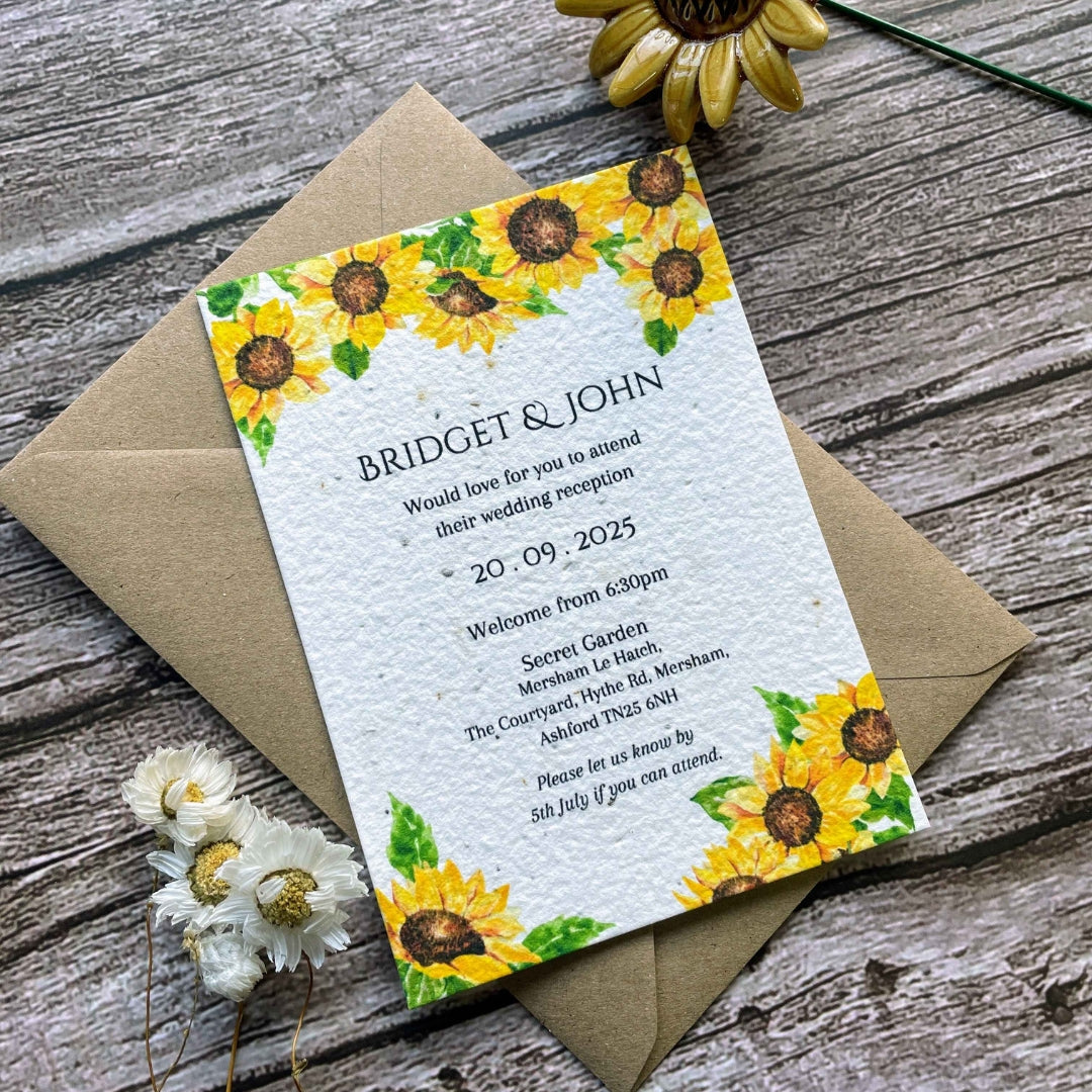 plantable evening guest wedding invitations in sunflowers theme, angled view with eco-friendly brown kraft envelope on wooden background