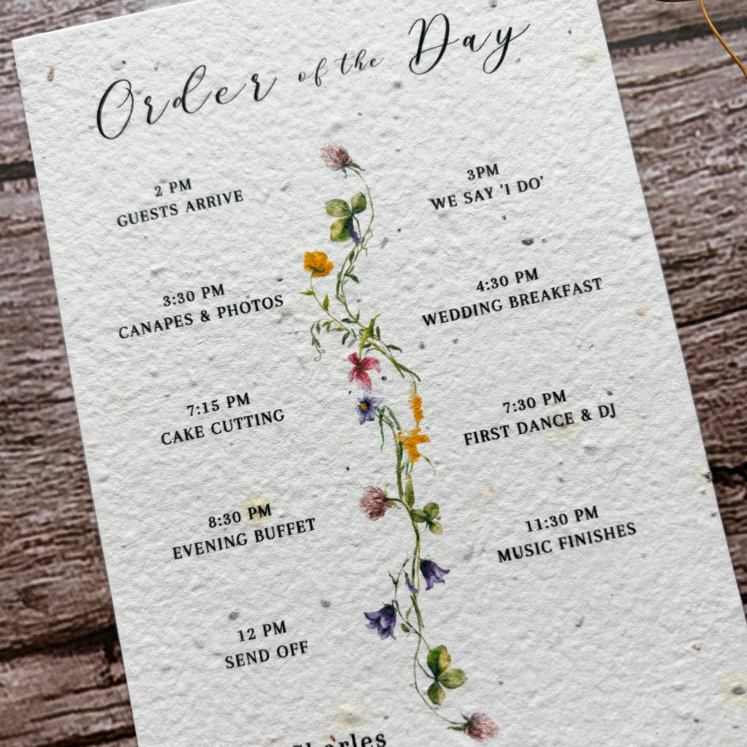 Wedding order of the day card with spring flower design on a wooden surface