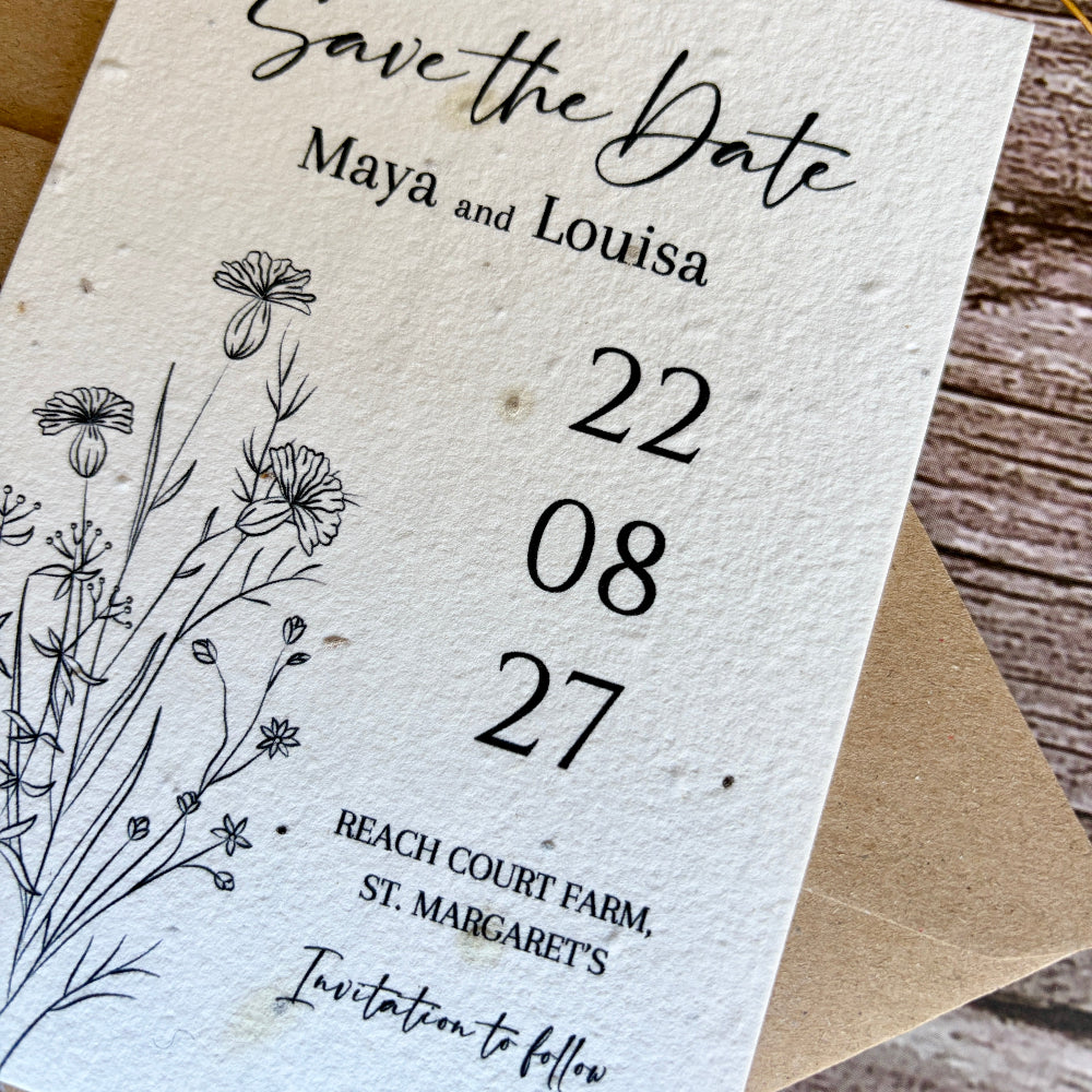 Plantable Save the Date card with floral design and text on a wooden surface