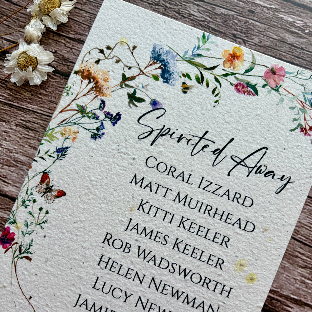 plantable seed paper seating plan cards with a wildflower meadow on a wooden background