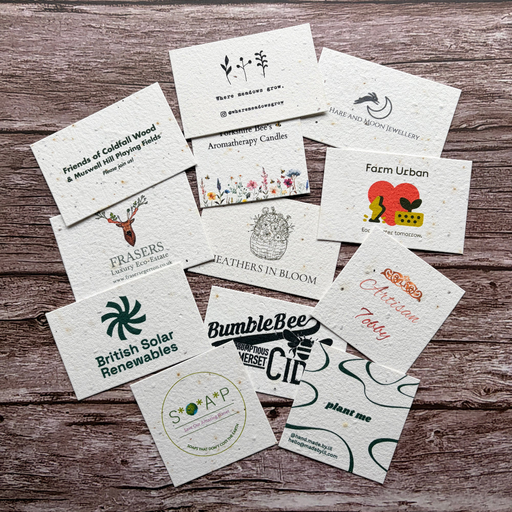 Collection of various plantable business cards on a wooden surface