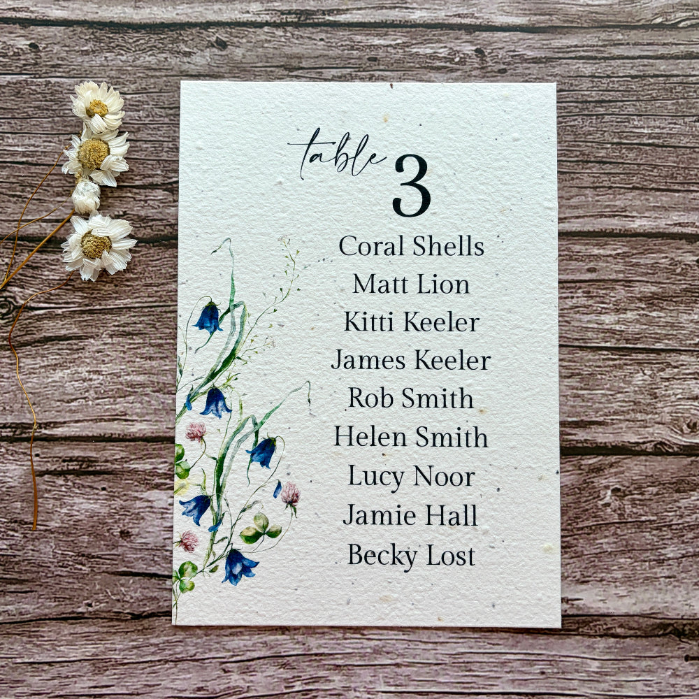 plantable wedding seating plan with lovers and bluebells design on a wooden background