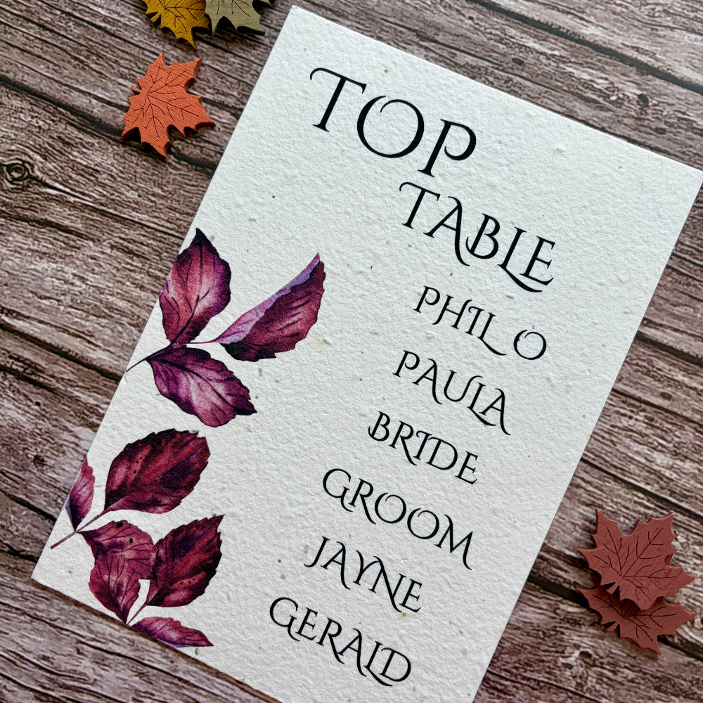 plantable wedding seating plan card with purple leaves on a wooden background