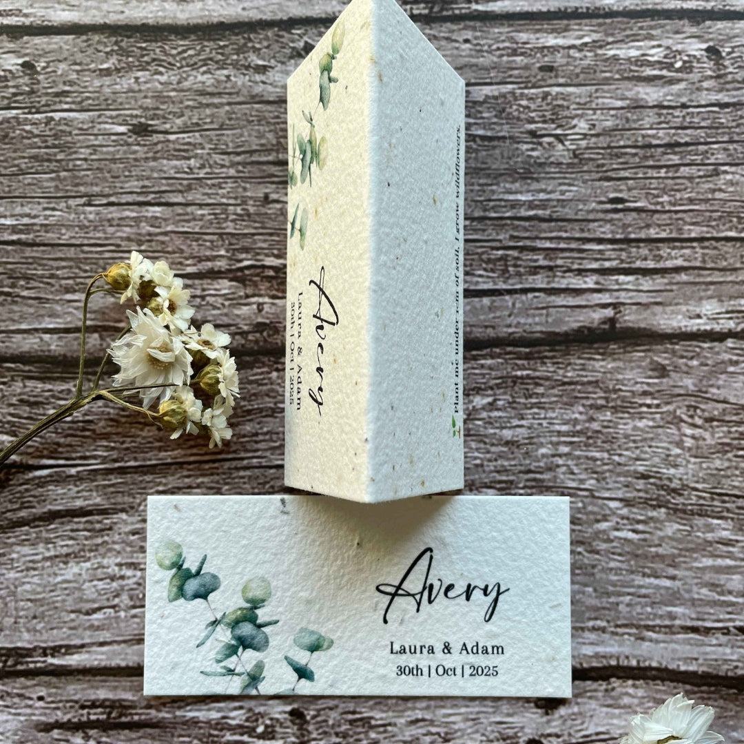 seed paper wedding place cards with eucalyptus design on a wooden surface