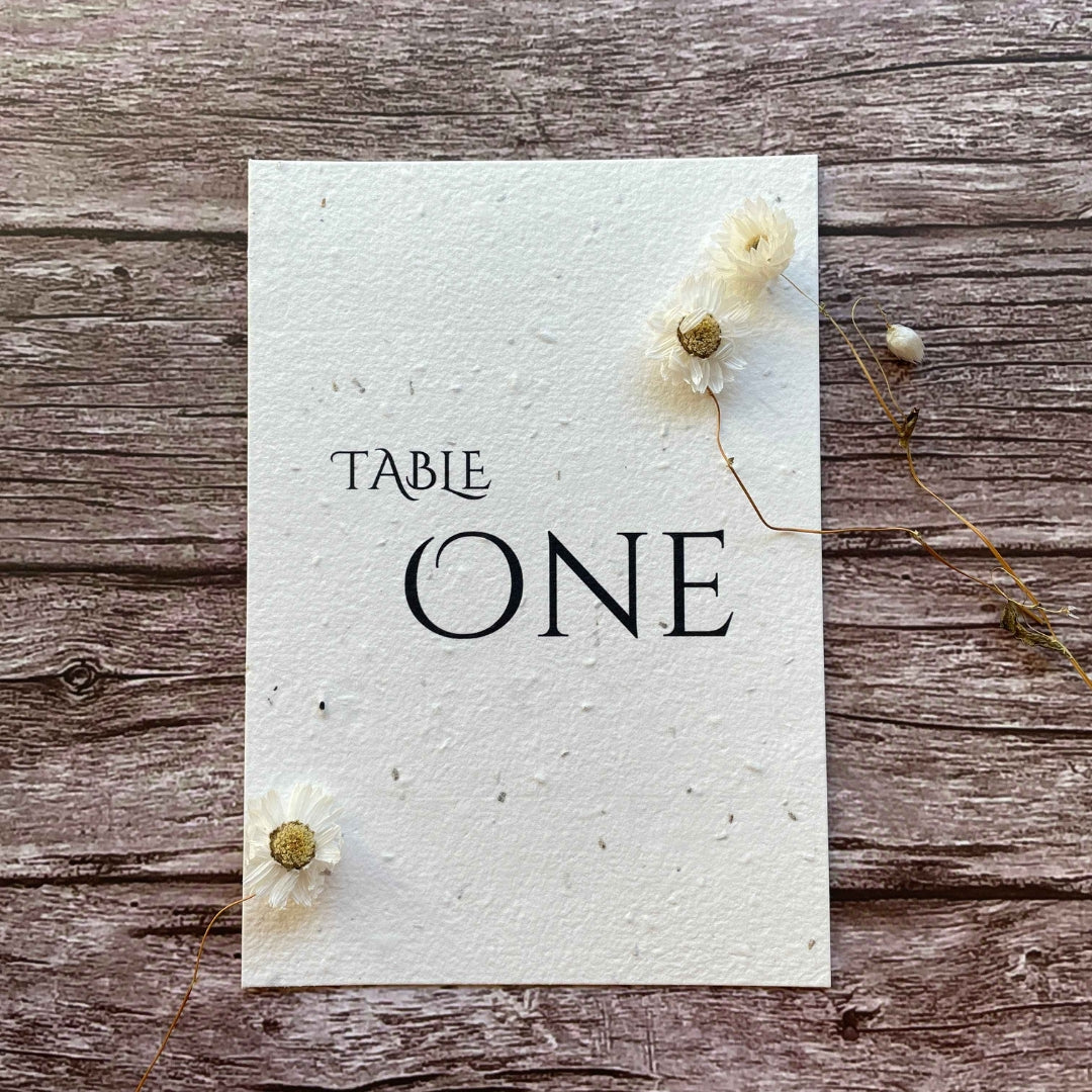 plantable seed paper wedding table number or name cards with minimalistic theme, front close-up view, eco-friendly wedding stationery, alakartcreations