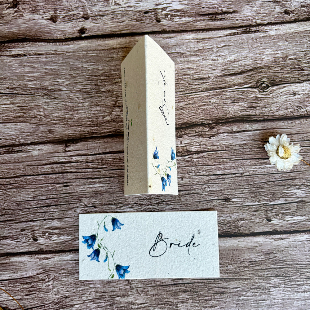 plantable seed paper wedding name cards with bluebells design on a wooden surface