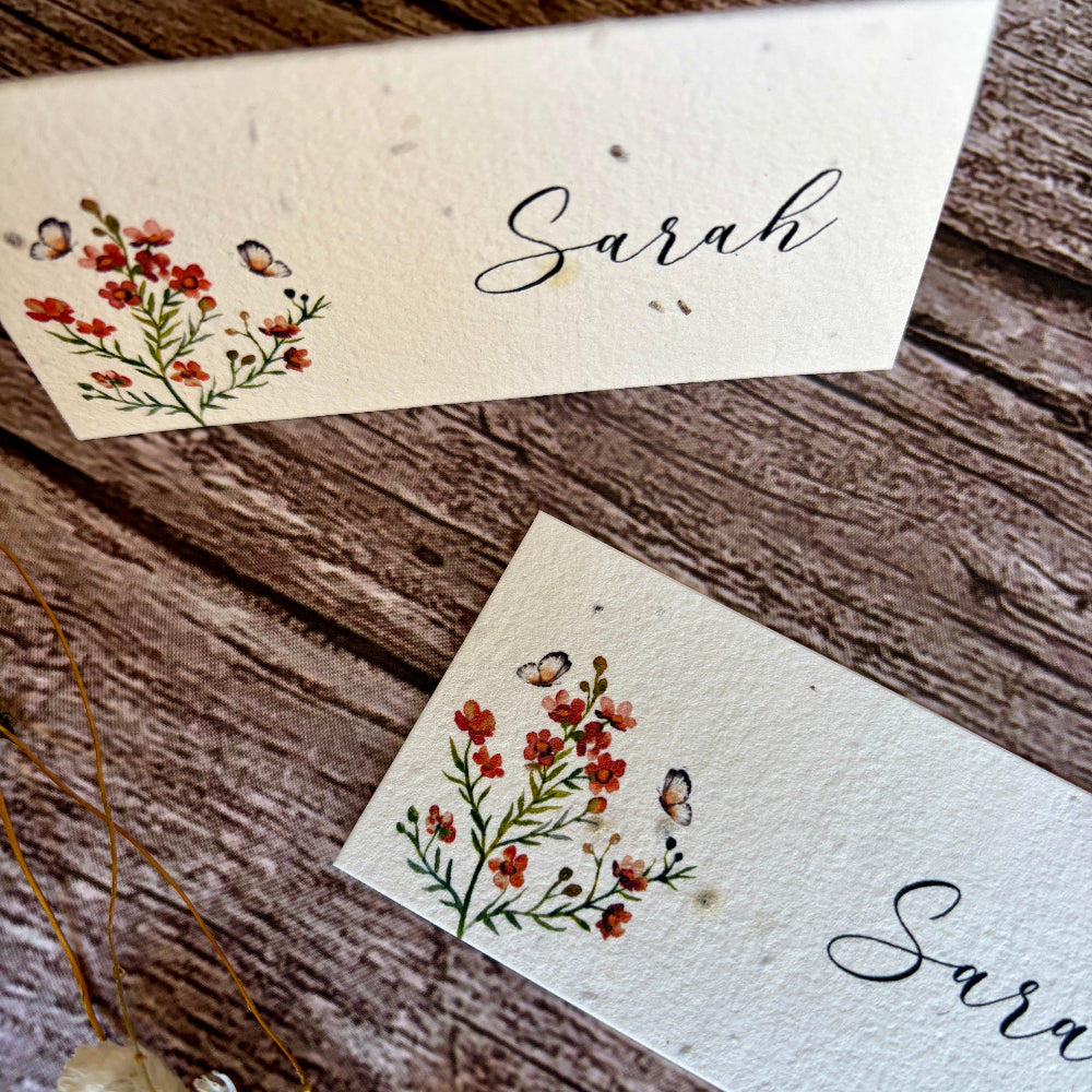 Two plantable place cards with floral designs and the name &
