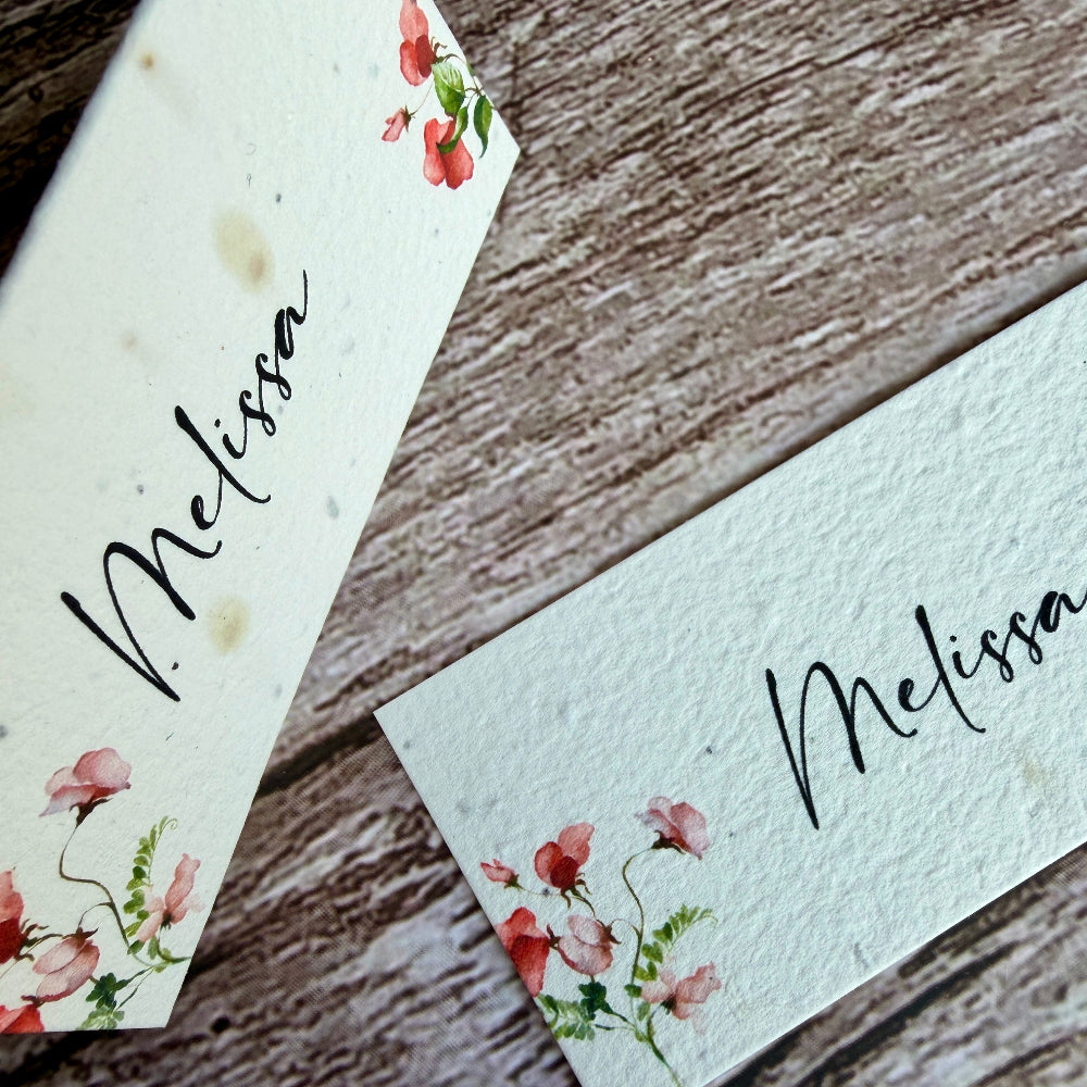 plantable seed paper name cards with sweet pea design on a wooden background