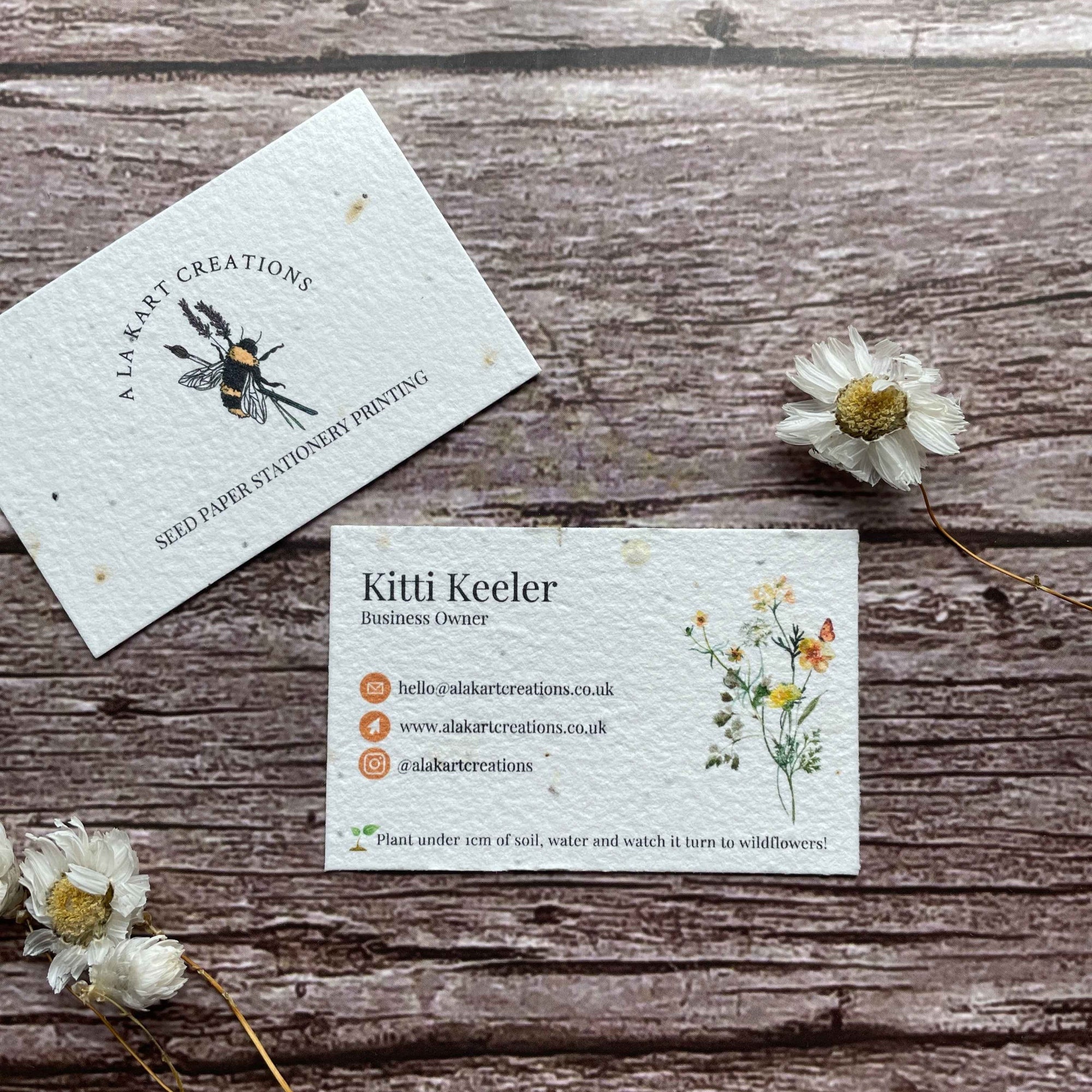 pre-designed plantable business cards with orange logo and wildflowers, showcasing eco-friendly floral design and sustainable branding, alakartcreations