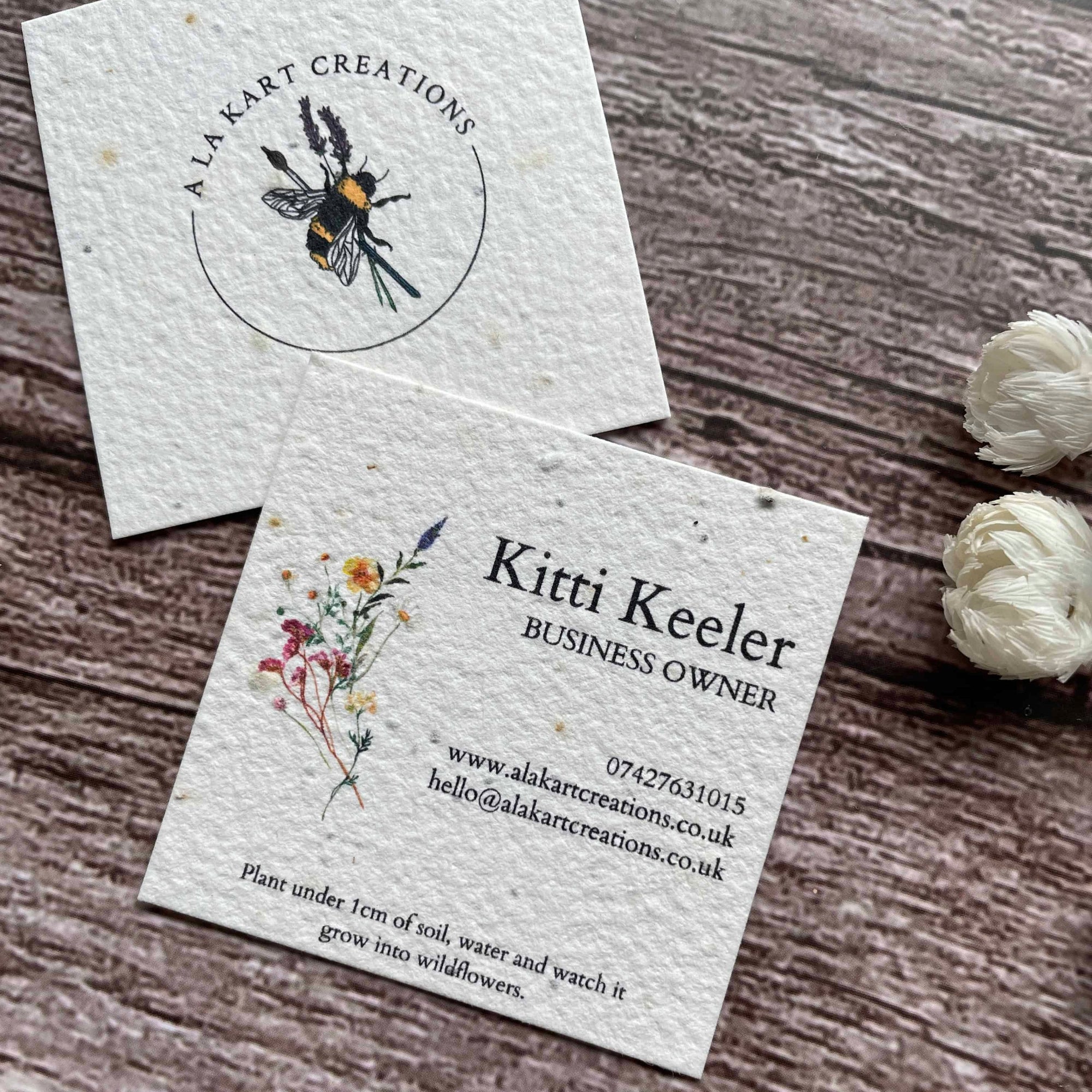 square plantable seed paper business cards with floral design featuring vibrant wildflowers, angled right, alakartcreations