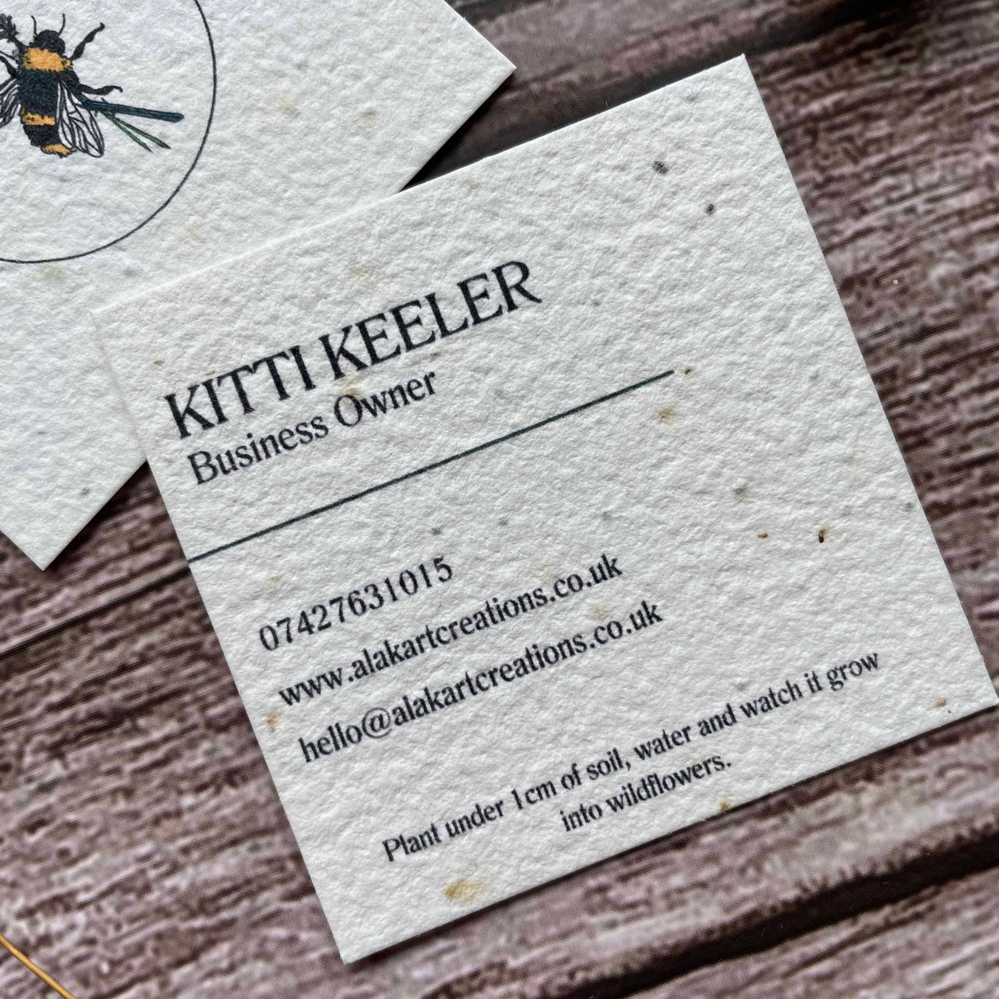 square plantable seed paper business cards with wildflower seeds, angled left showing closeup of custom information, alakartcreations