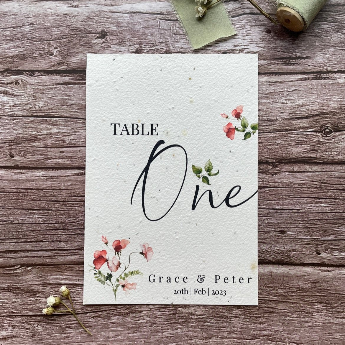 plantable seed paper wedding table number or name cards in sweet pea theme, front view with floral design on wooden background, eco-friendly, alakartcreations