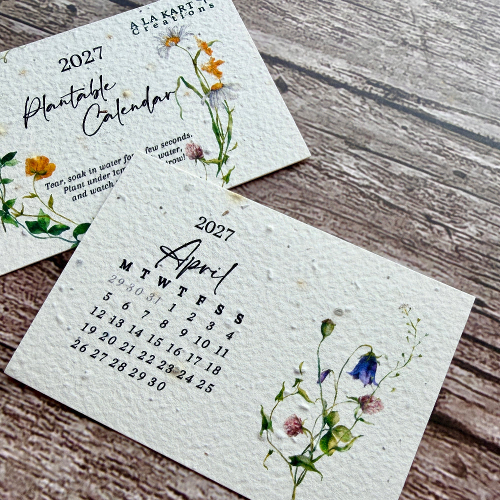 Two small textured paper plantable calendar cards for 2027, one showing the full monthly layout with floral illustrations and the other partially visible above showing &