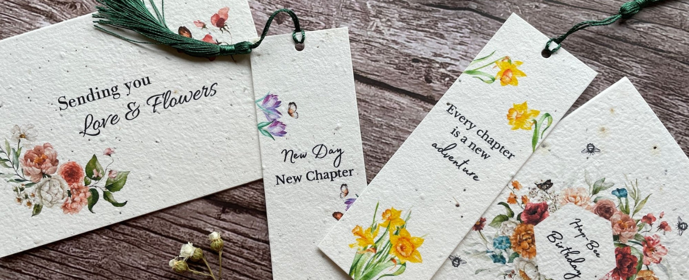 A range of A La KArt Creations handmade plantable greeting cards and plantable bookmarks, laid out on a wooden back drop to promote their wholesale range.