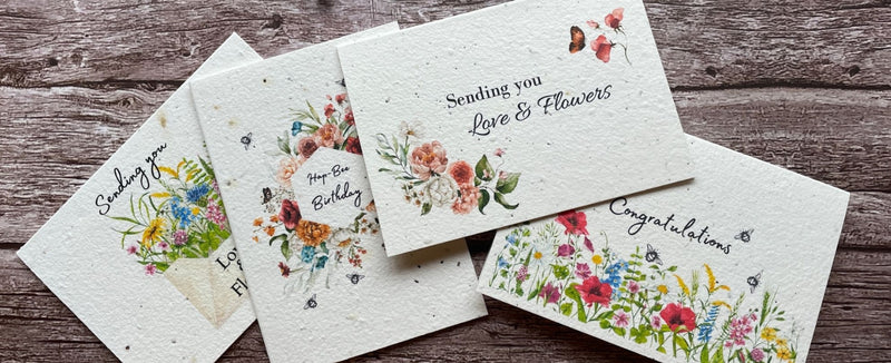 A La KArt Creations plantable greeting cards, laid out on a wooden back drop. Featuring 'Sending you love & Flowers', 'Congratulations', and 'Hap-Bea Birthday'.