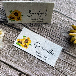 plantable seed paper wedding guest place cards in sunflower theme, showing flat and standing angled views on wooden background, eco-friendly