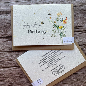 Two planrable greeting cards on a wooden surface, one with floral design and 'Happy Birthday' text