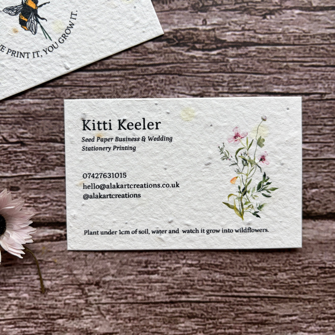 Seed paper business card with floral design on a wooden surface