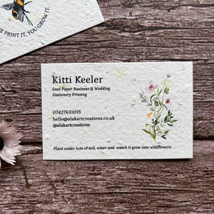 Seed paper business card with floral design on a wooden surface