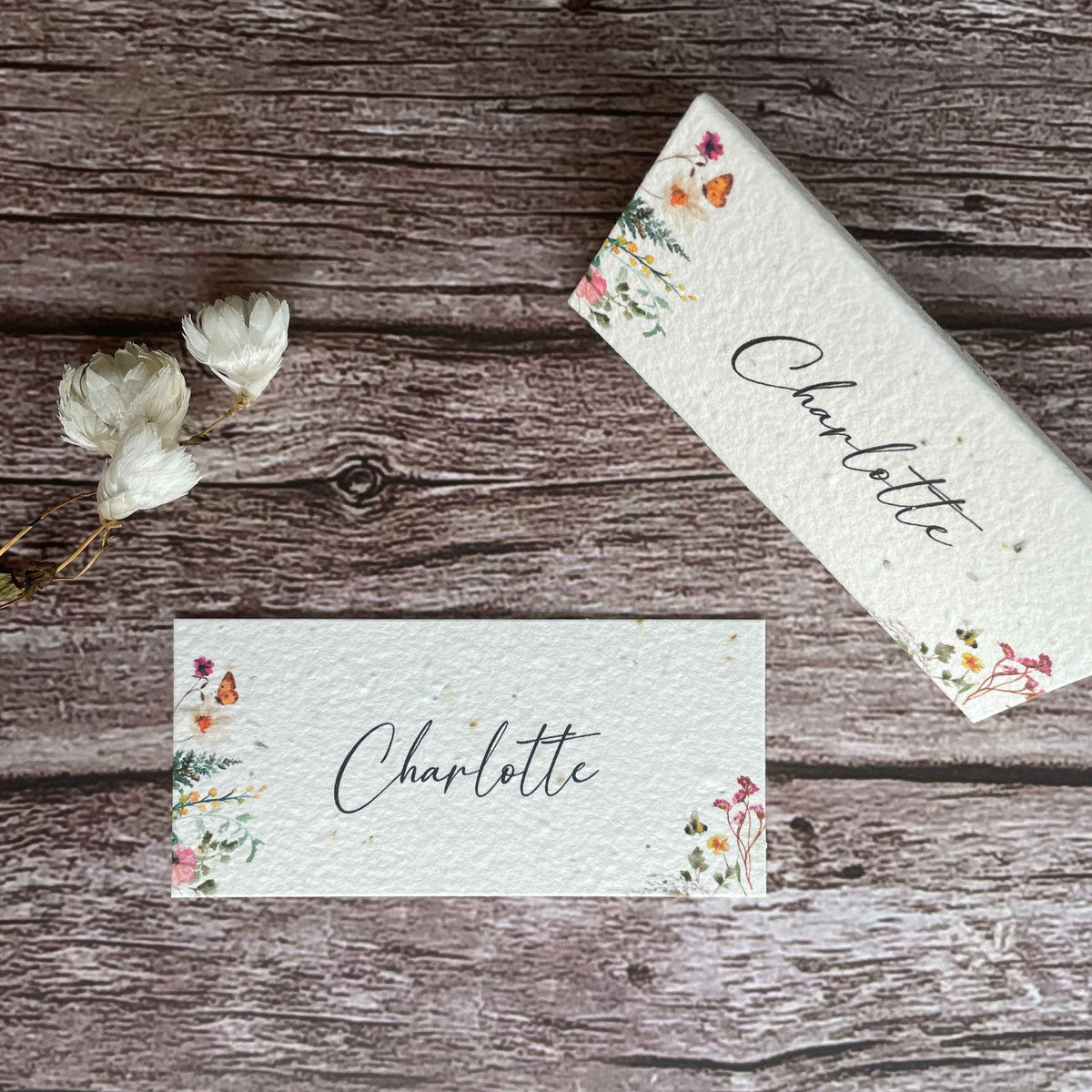 front view of plantable wedding name cards with standing card on the right above, featuring wildflower design, from a la kart creations