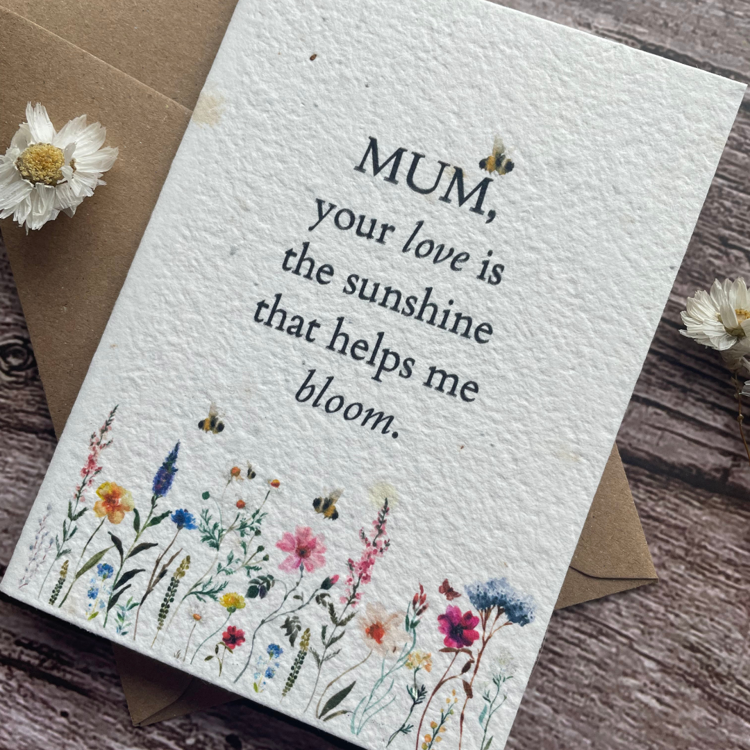 angled view of personalised plantable mother's day card with wildflowers and bees, message "mum your love is the sunshine that helps me bloom"
