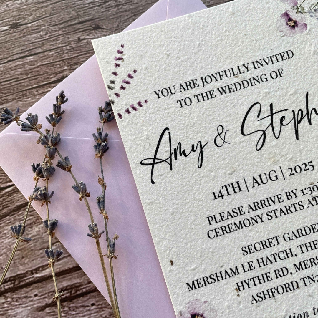 personalised plantable wedding invitations lilac theme, angled view with colour matched envelope, and qr code rsvp with lavender on wooden background