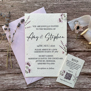 personalised plantable wedding invitations lilac theme, front view with colour matched envelope, and qr code rsvp on wooden background