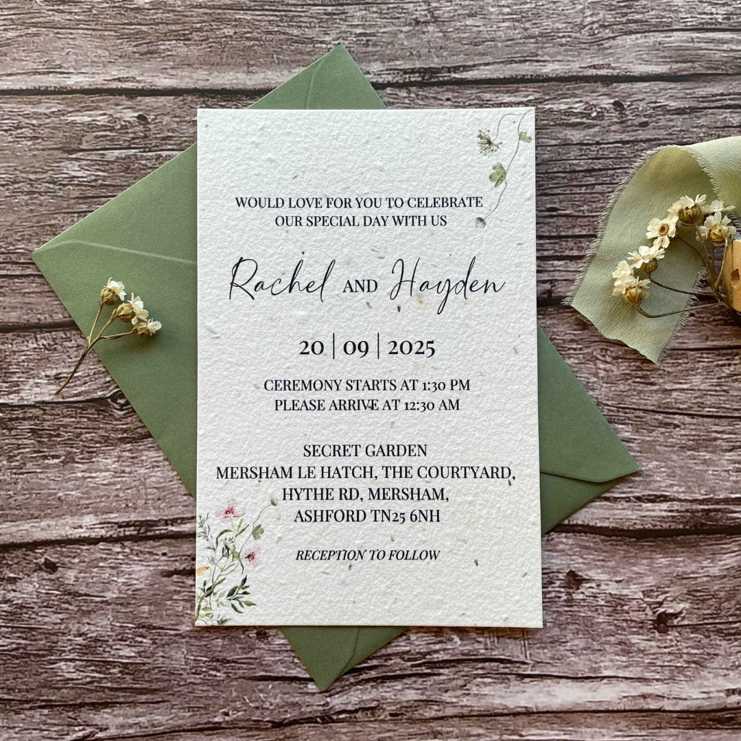 personalised plantable wedding invitations in spring green theme, showing front view with colour matched envelope, floral design on wooden background