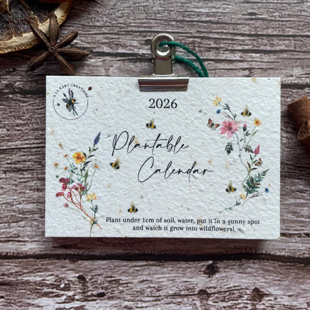 seed paper 2026 plantable calendar with wildflower design on wooden backdrop