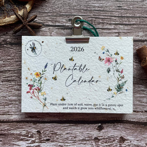 seed paper 2026 plantable calendar with wildflower design on wooden backdrop