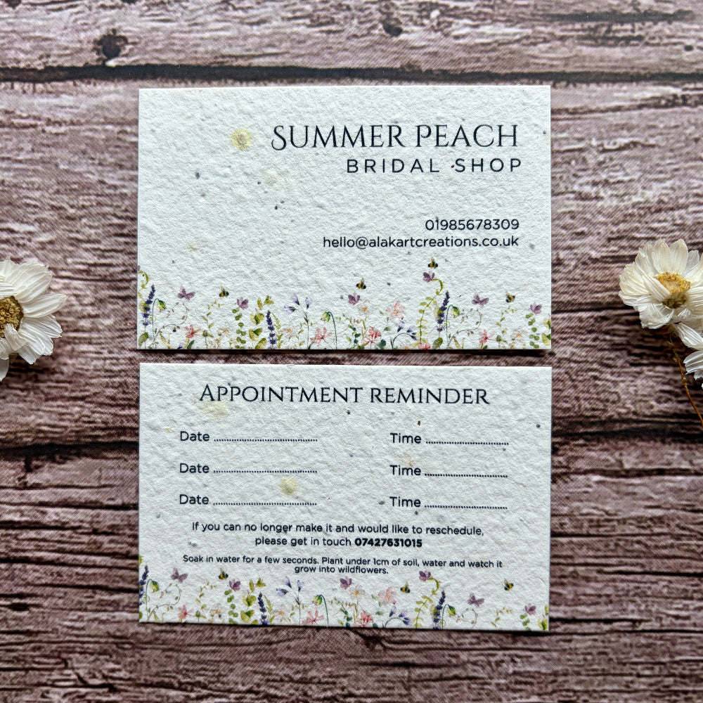 Plantable appointment reminder card from Summer Peach Bridal Shop on a wooden surface with flowers.