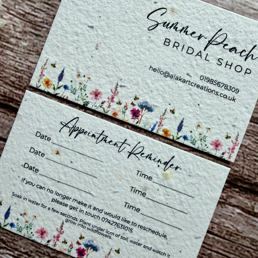 Seed paper appointment reminder card with floral design on a wooden surface