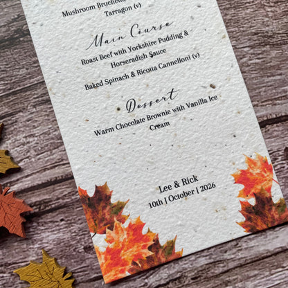 Wedding Menu made from seed paper with autumn leaf design on a wooden surface