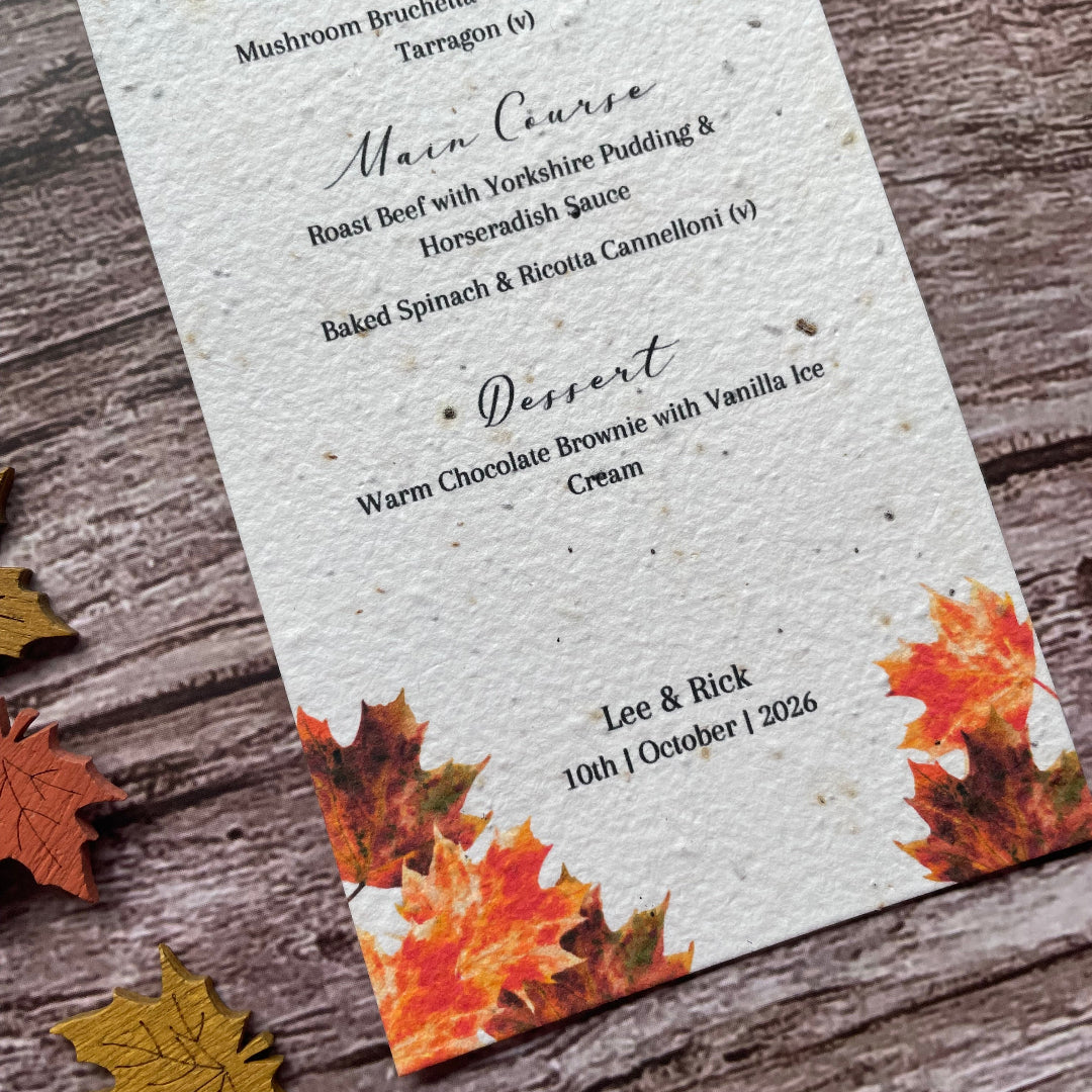 Wedding Menu made from seed paper with autumn leaf design on a wooden surface