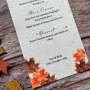 Wedding Menu made from seed paper with autumn leaf design on a wooden surface