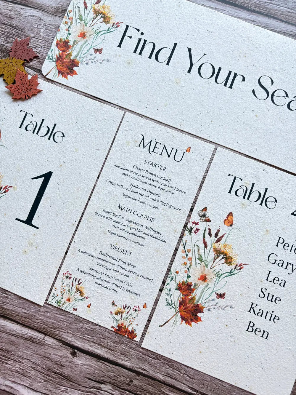 Table autumn wedding seating arrangement with floral design on a wooden surface made from seed paper