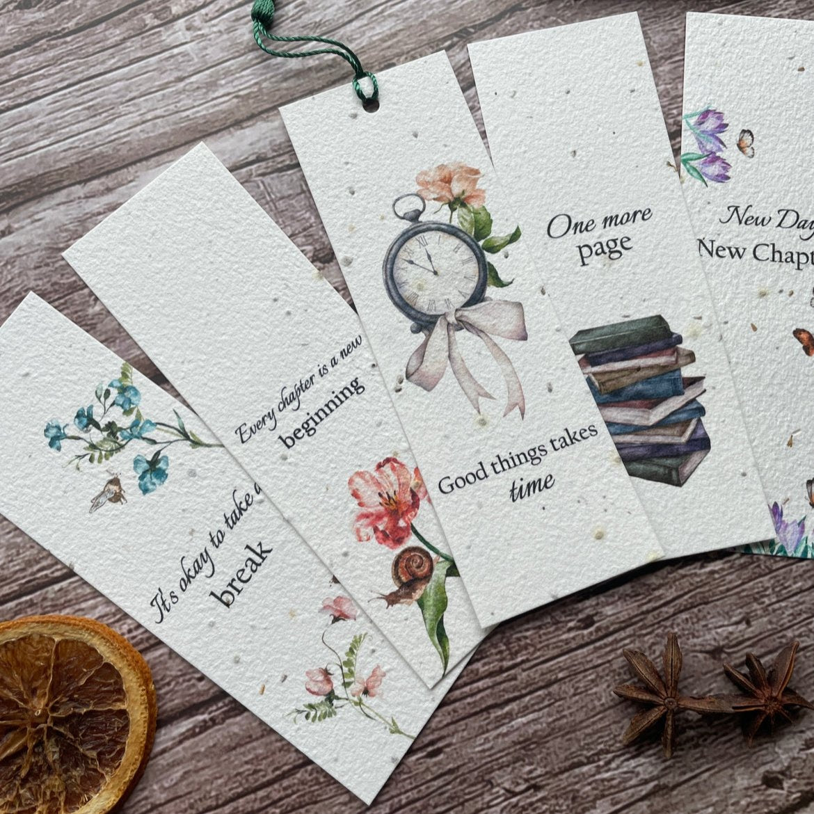 angled view of eco-friendly plantable bookmarks with designs of clocks, books, snail on a flower, and butterflies