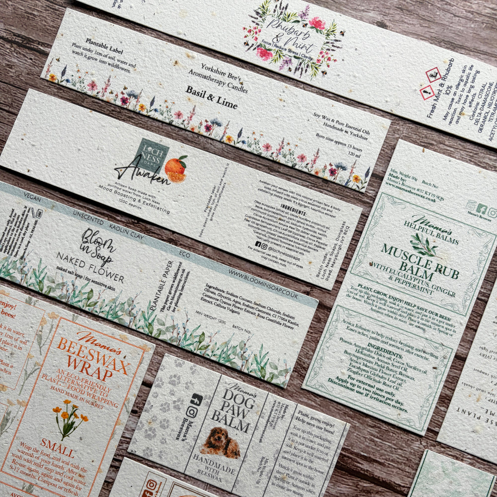 Collection of various plantable seed paper product labels on a wooden surface