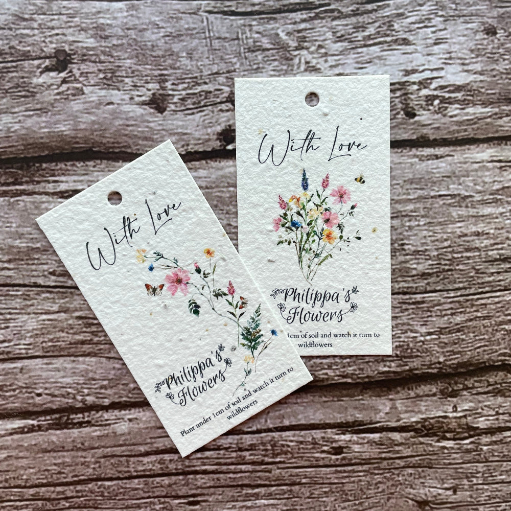 Two plantable floral gift tags on a wooden surface