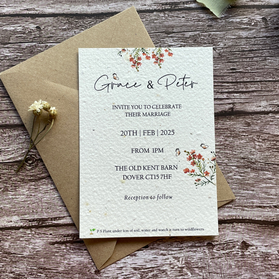 plantable seed paper wedding invites with orange flowers on a wooden surface