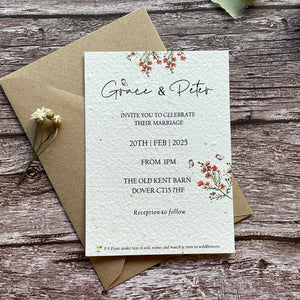 plantable seed paper wedding invites with orange flowers on a wooden surface