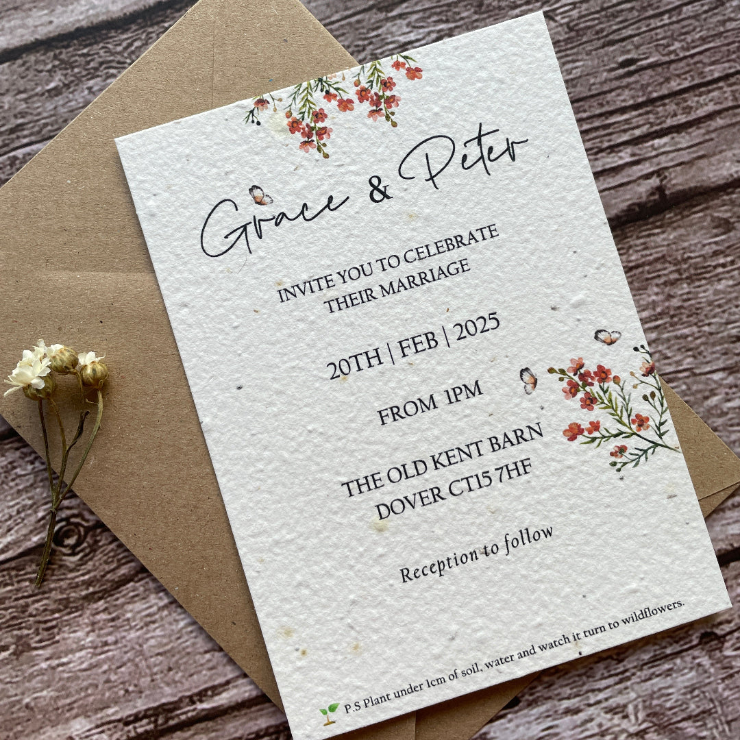 seed paper wedding main invites with flowers on a wooden surface