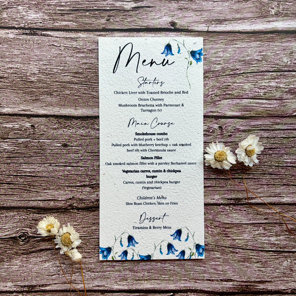 Plantable menu card with bluebells design on a wooden surface