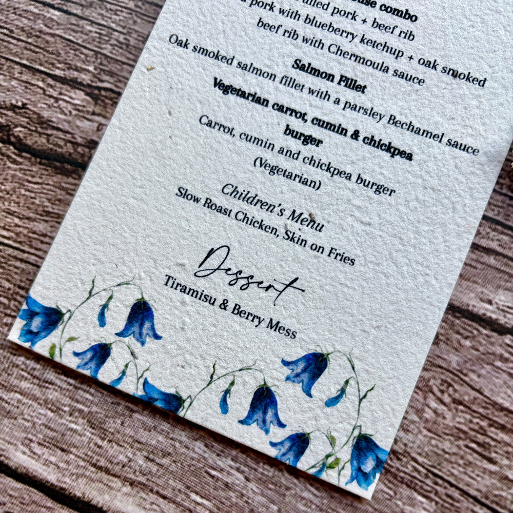 plantable menu card with bluebells design on a wooden surface