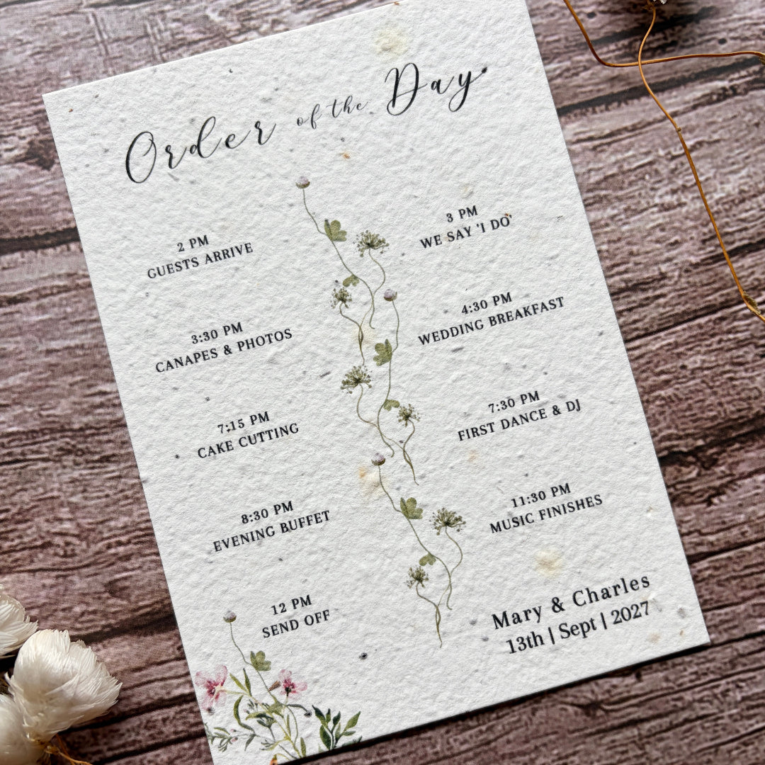 Wedding order of the day card with floral design on a wooden surface