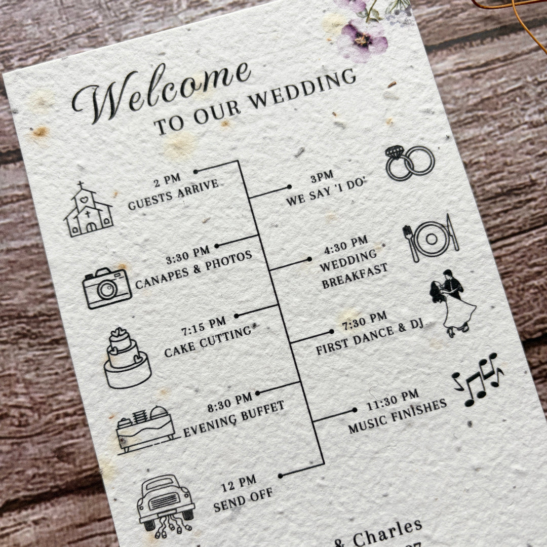 Wedding timeline card with lilac flowers and text on a wooden surface