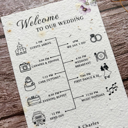 Wedding timeline card with lilac flowers and text on a wooden surface