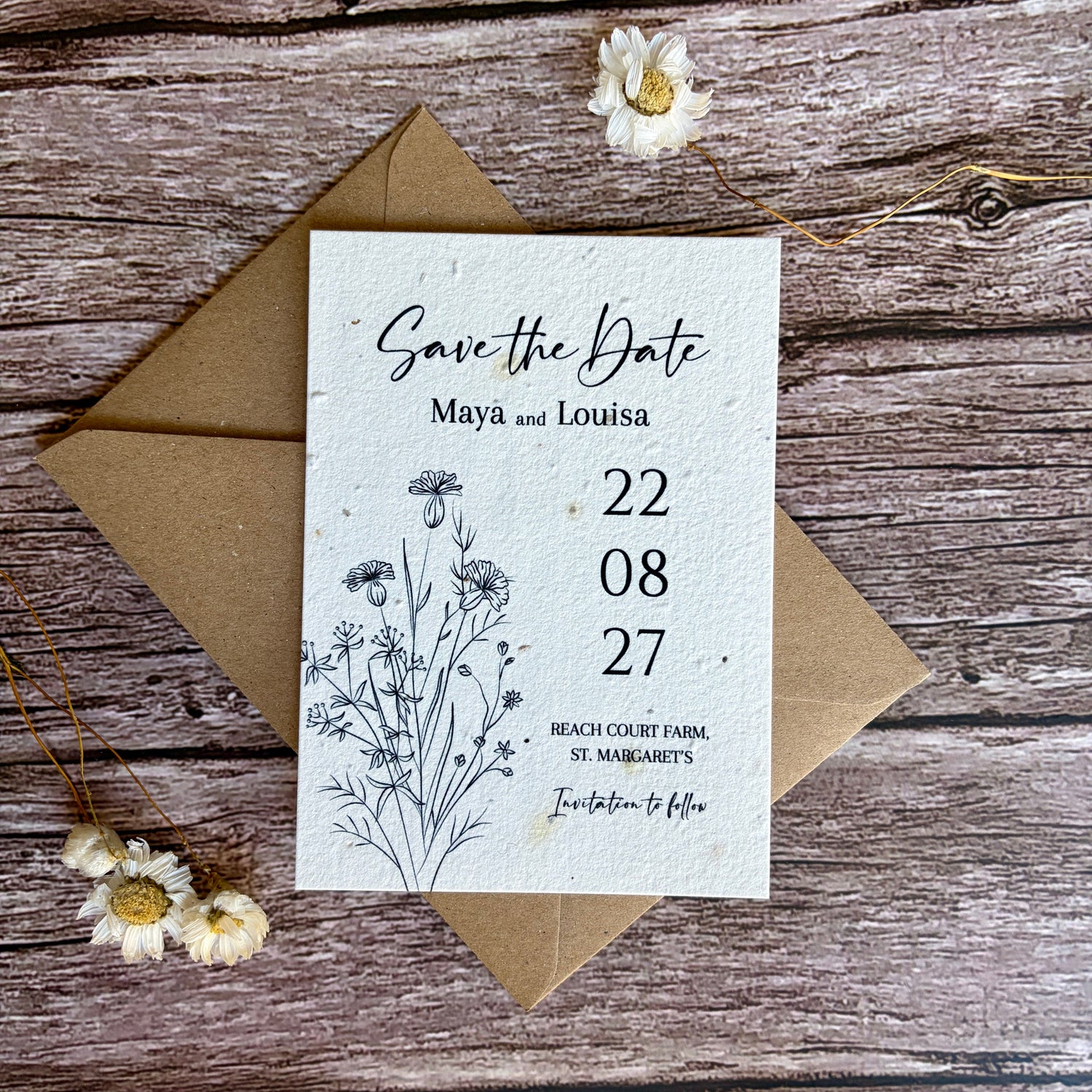 plantable save the dates with line drawn cornflowers on a wooden surface