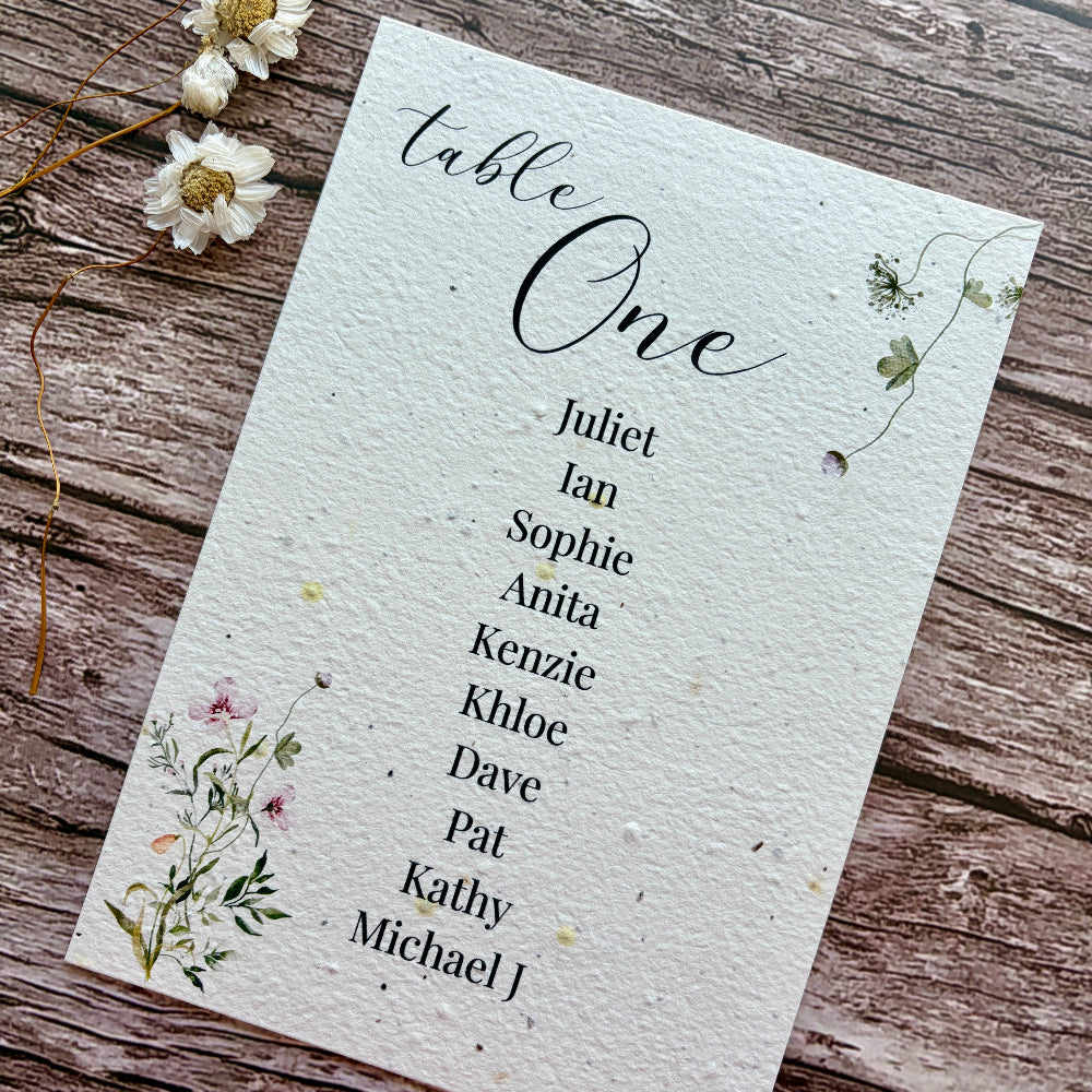 Table one seating arrangement plantable card with floral design on a wooden surface