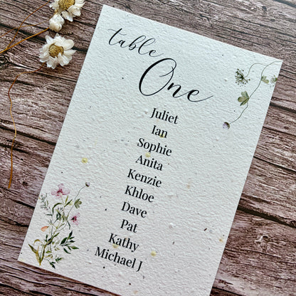 Table one seating arrangement plantable card with floral design on a wooden surface